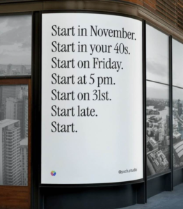 A large print ad posted in a window says the following in black text on a white background: "Start in November. Start in your 40s. Start on Friday. Start at 5 pm. Start on 31st. Start late. Start."